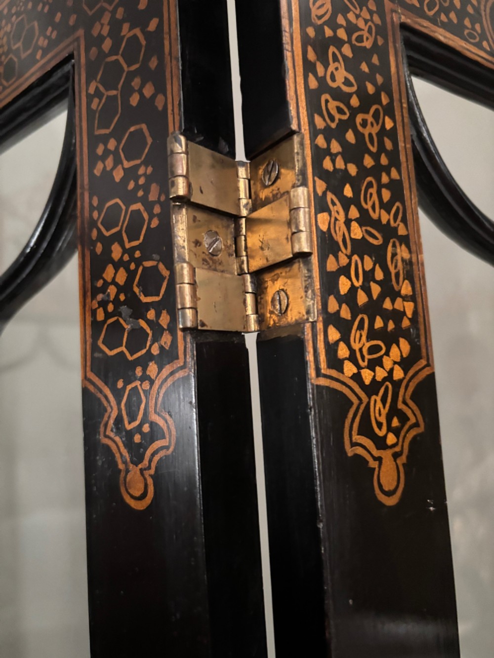 A four-fold black lacquered screen with Chinese Chippendale fretwork crestings, glazed upper panels, and incised gold chinoiserie landscape scenes. View IX