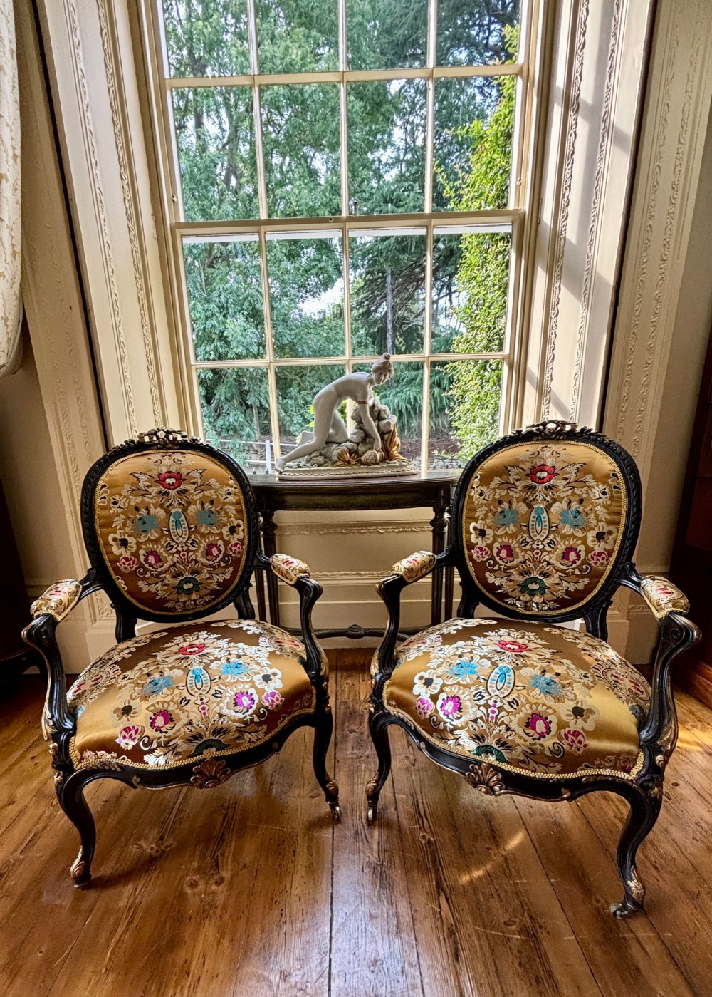 A pair of 19th-century French open armchairs with dark carved walnut frames, cabriole legs, and ornate gold silk brocade upholstery featuring floral motifs. View II