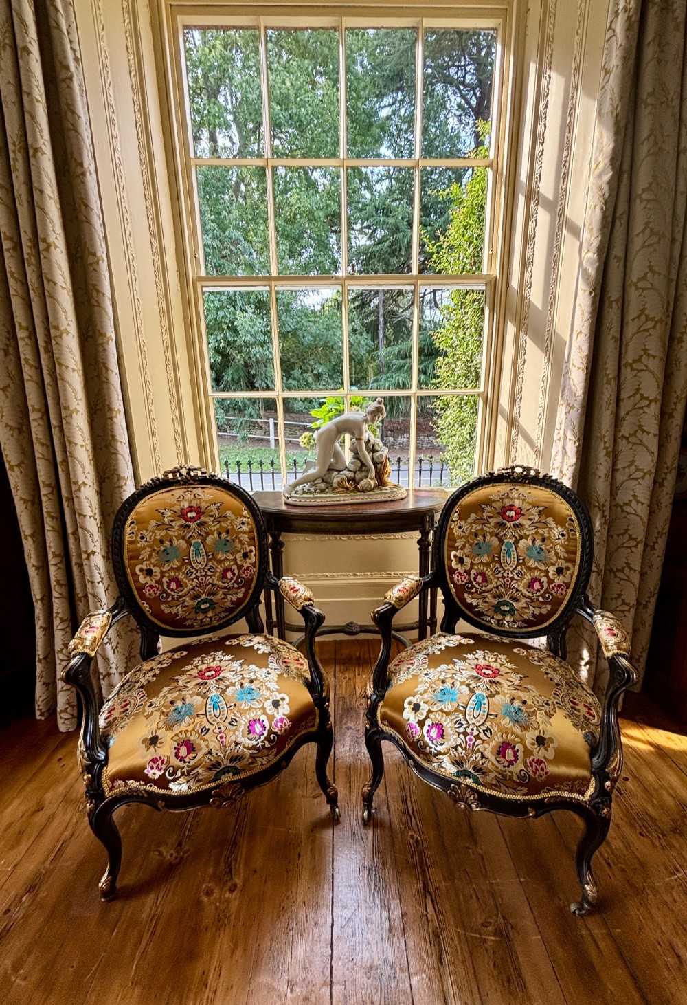 A pair of 19th-century French open armchairs with dark carved walnut frames, cabriole legs, and ornate gold silk brocade upholstery featuring floral motifs. View III