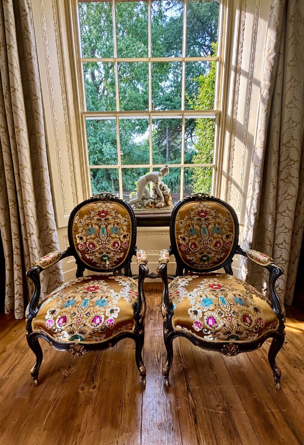 A pair of 19th-century French open armchairs with dark carved walnut frames, cabriole legs, and ornate gold silk brocade upholstery featuring floral motifs. View VI