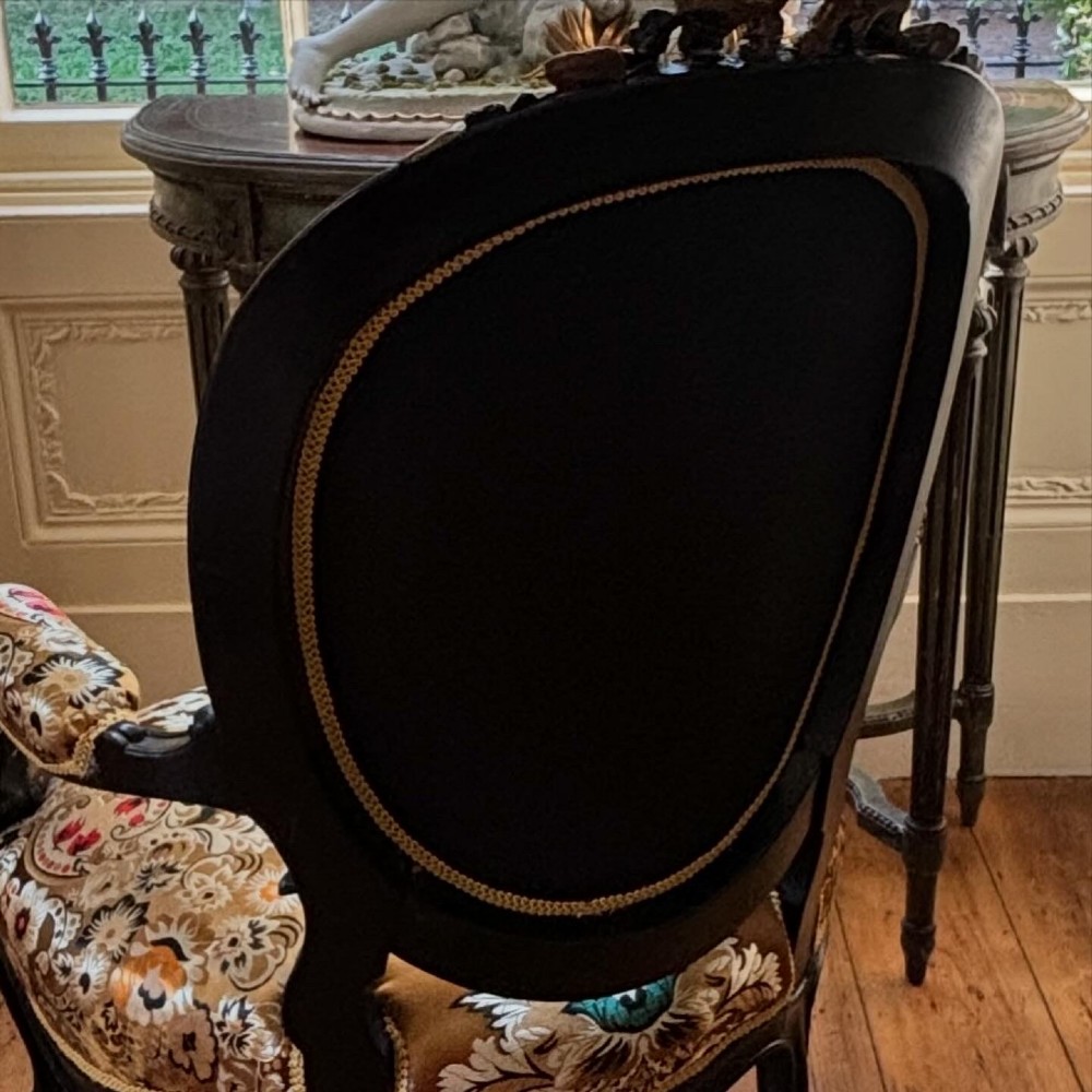 A pair of 19th-century French open armchairs with dark carved walnut frames, cabriole legs, and ornate gold silk brocade upholstery featuring floral motifs. View VIII