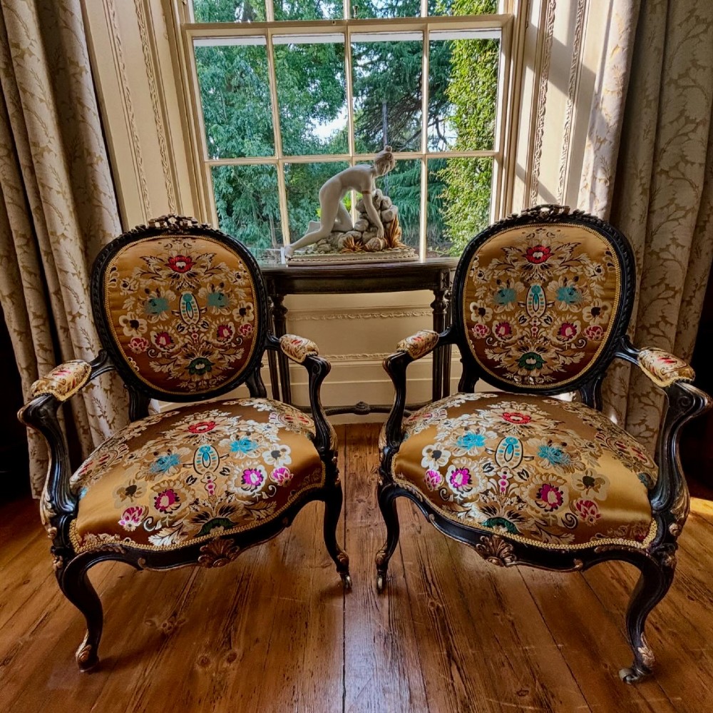 A pair of 19th-century French open armchairs with dark carved walnut frames, cabriole legs, and ornate gold silk brocade upholstery featuring floral motifs. View XI