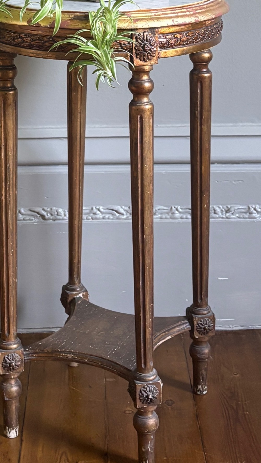 A French circa 1820 circular giltwood side table featuring a white marble top, fluted tapered legs, rosette carvings, and a low curved stretcher. View VIII