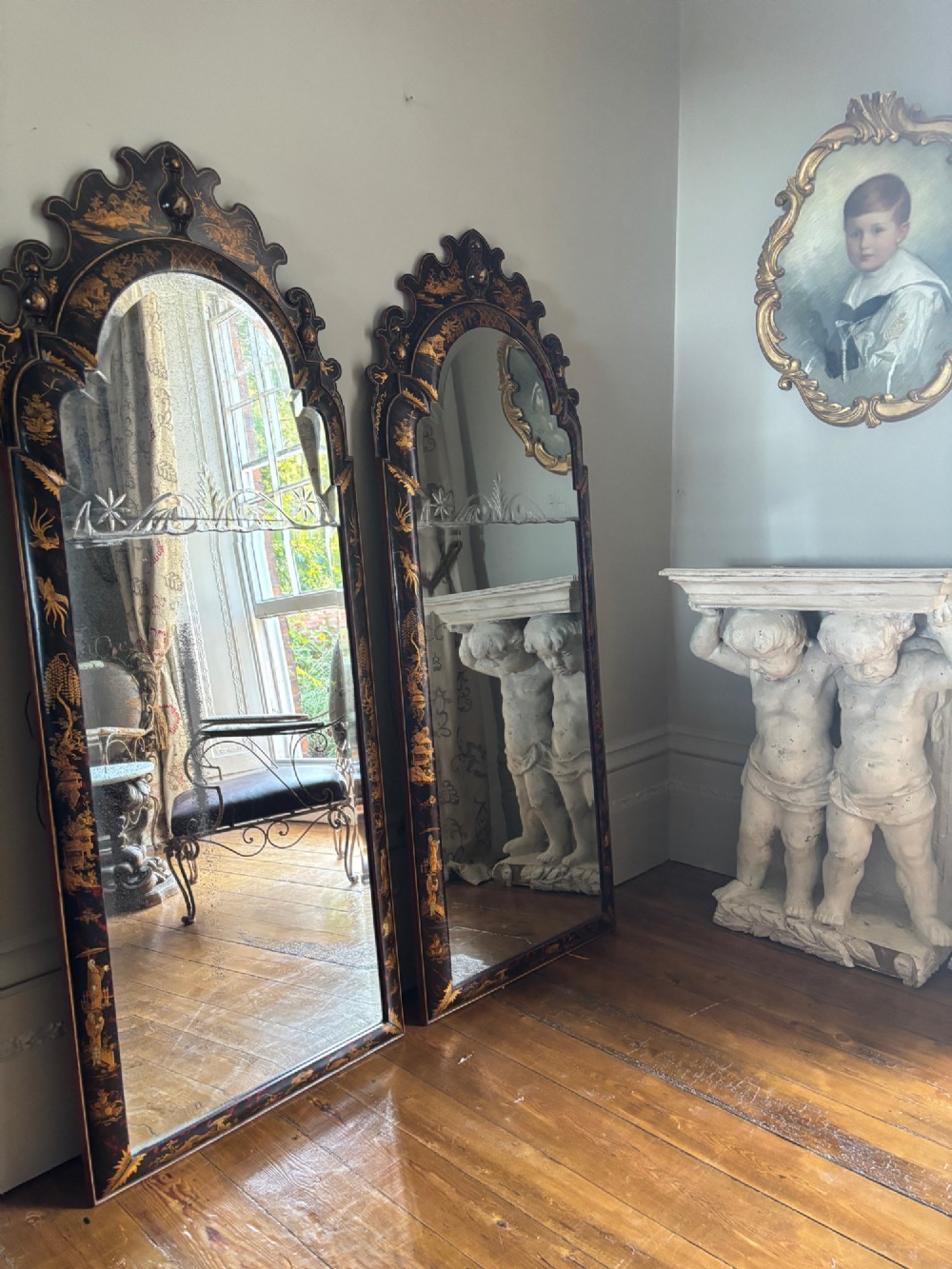 A pair of tall arched Queen Anne style pier mirrors featuring black lacquered frames decorated with gilded chinoiserie motifs and star-etched glass upper panels. View II
