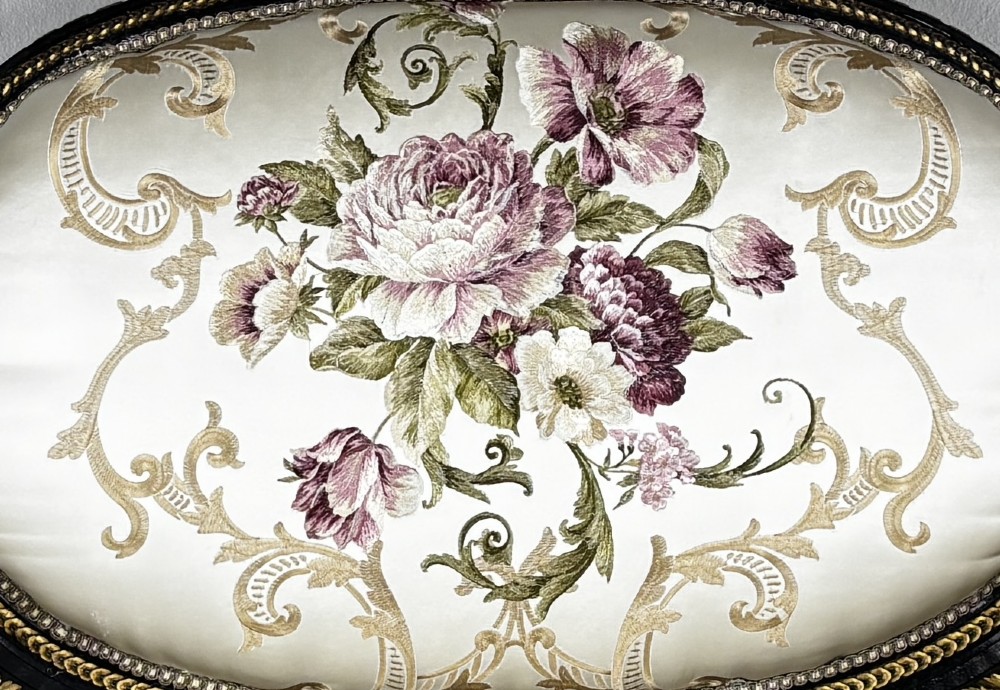 A French Louis XVI style settee featuring an ebonised frame with gilt details and cream silk upholstery. View III
