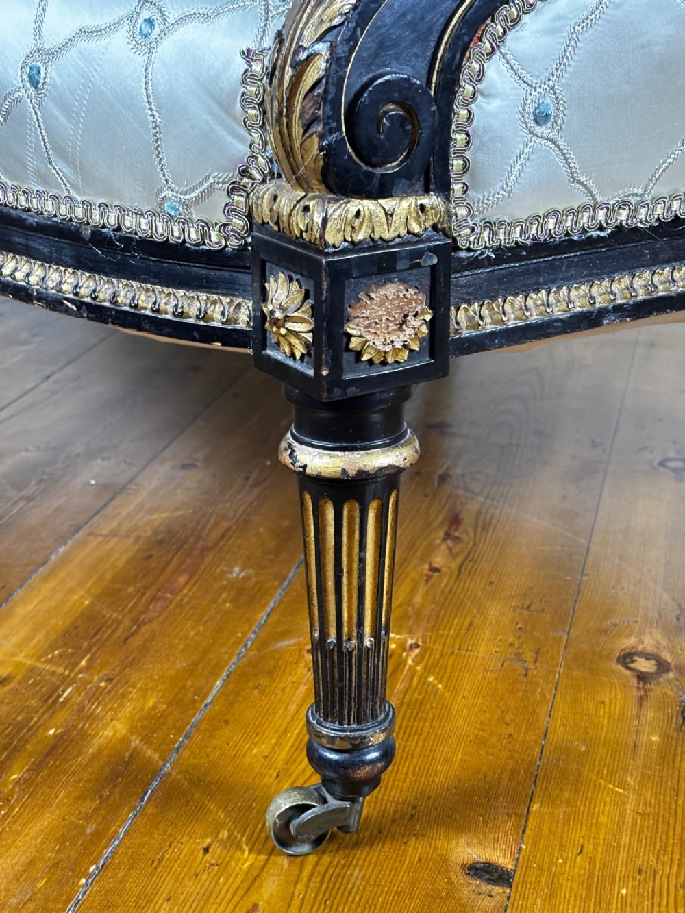 A French Louis XVI style settee featuring an ebonised frame with gilt details and cream silk upholstery. View VIII