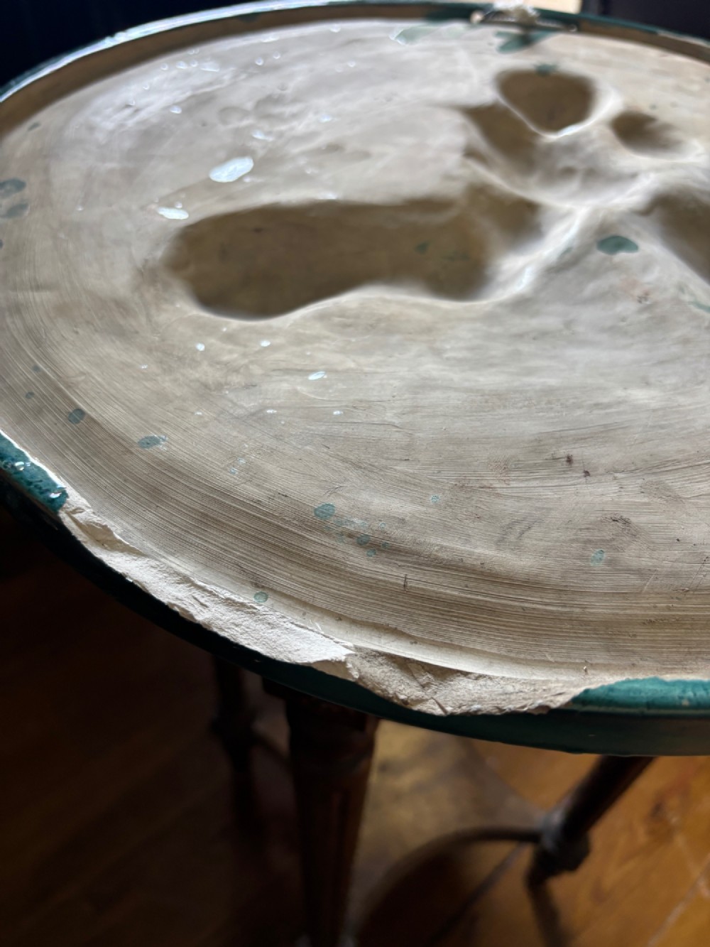 A circular turquoise-glazed ceramic plaque depicting cherubs sculpted in high relief holding flowing drapery. View III
