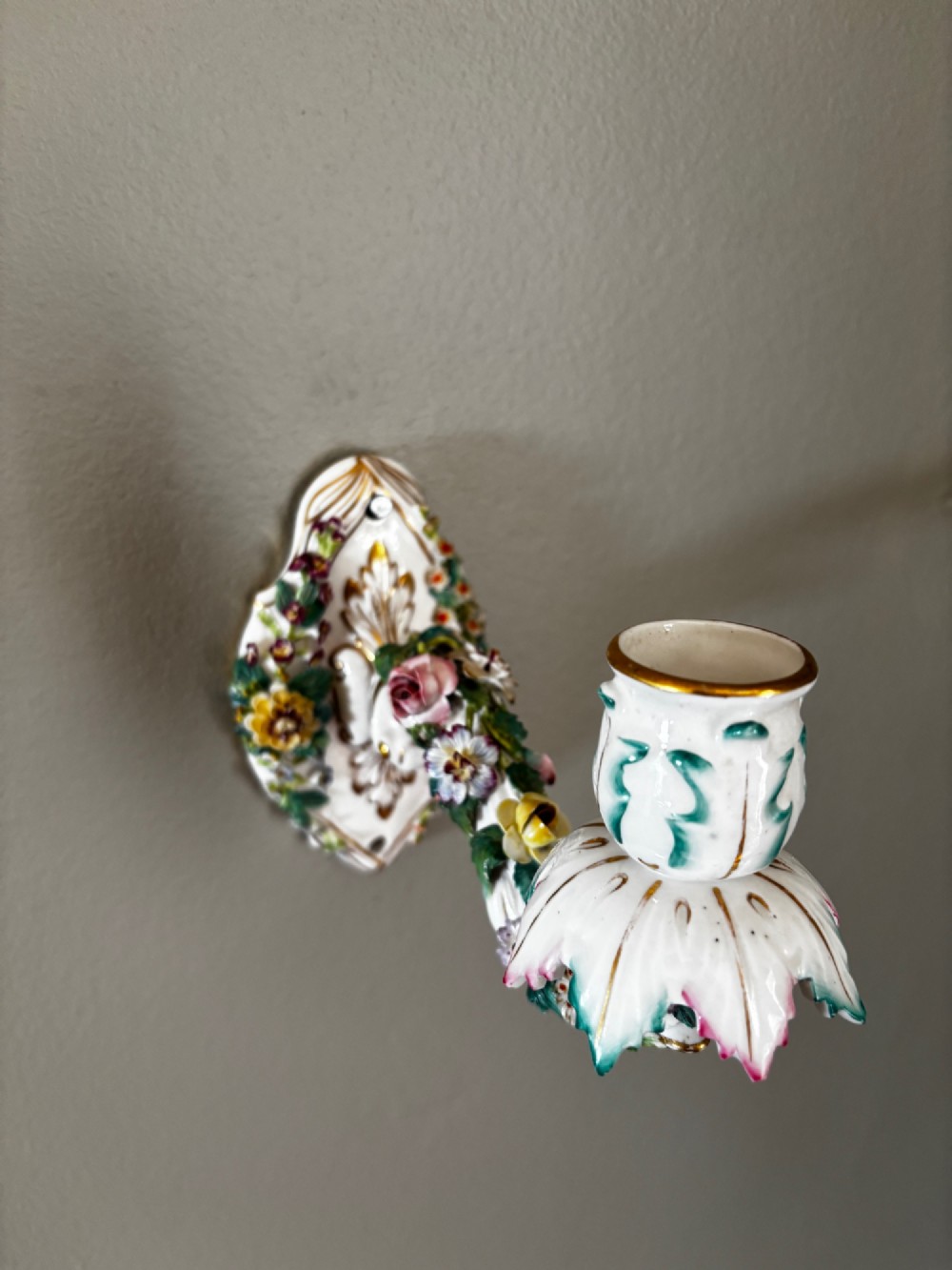 An antique Meissen hard-paste porcelain single candle wall sconce decorated with applied colourful flowers, gilt rococo scrollwork backplate, and a petal-shaped candle socket. View II