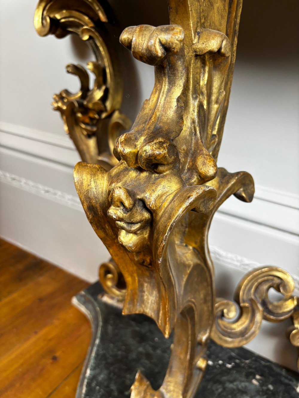 Late eighteenth-century Venetian giltwood console table featuring carved scroll supports, a shaped plinth base, and a polished dark timber top. View IV