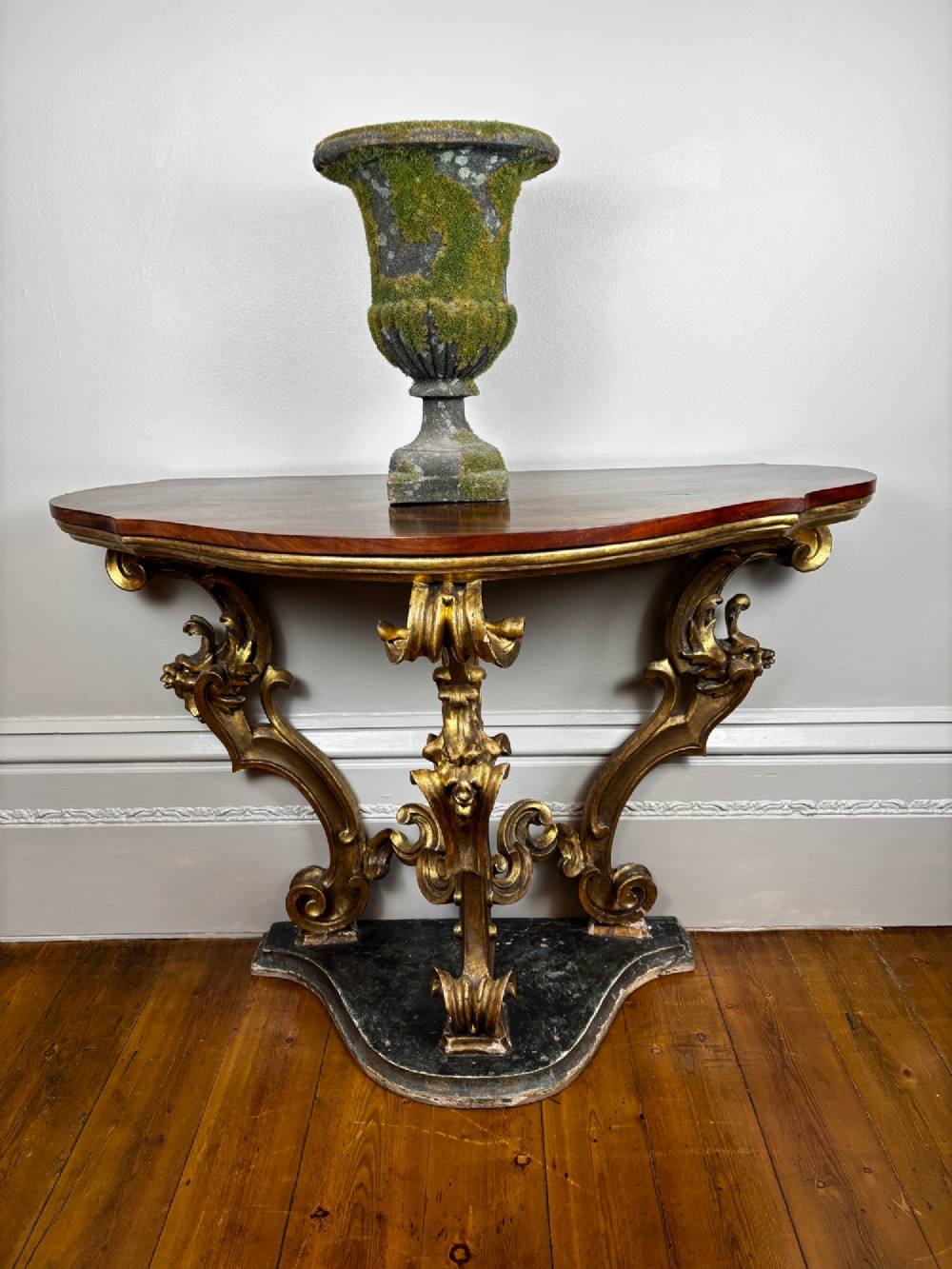 Late eighteenth-century Venetian giltwood console table featuring carved scroll supports, a shaped plinth base, and a polished dark timber top. View VIII