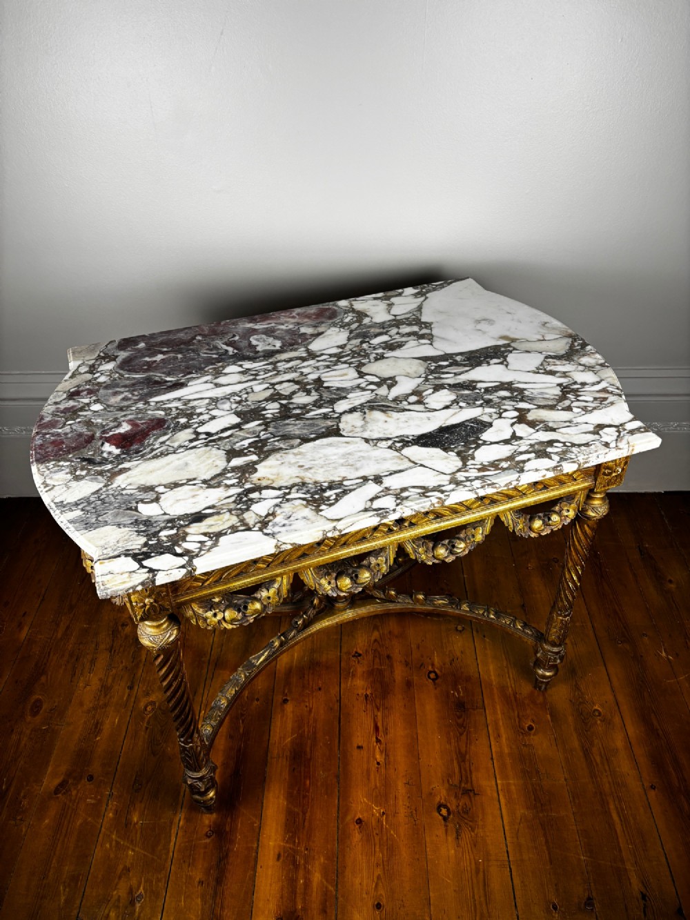 An early 20th-century French Louis XV Revival giltwood console table with a carved openwork apron, spiralled legs, curved stretcher, and fitted white marble top. View III