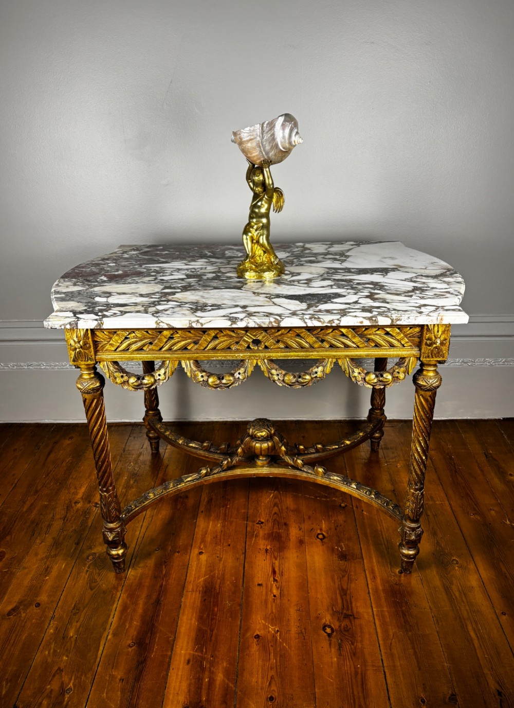 An early 20th-century French Louis XV Revival giltwood console table with a carved openwork apron, spiralled legs, curved stretcher, and fitted white marble top. View VIII