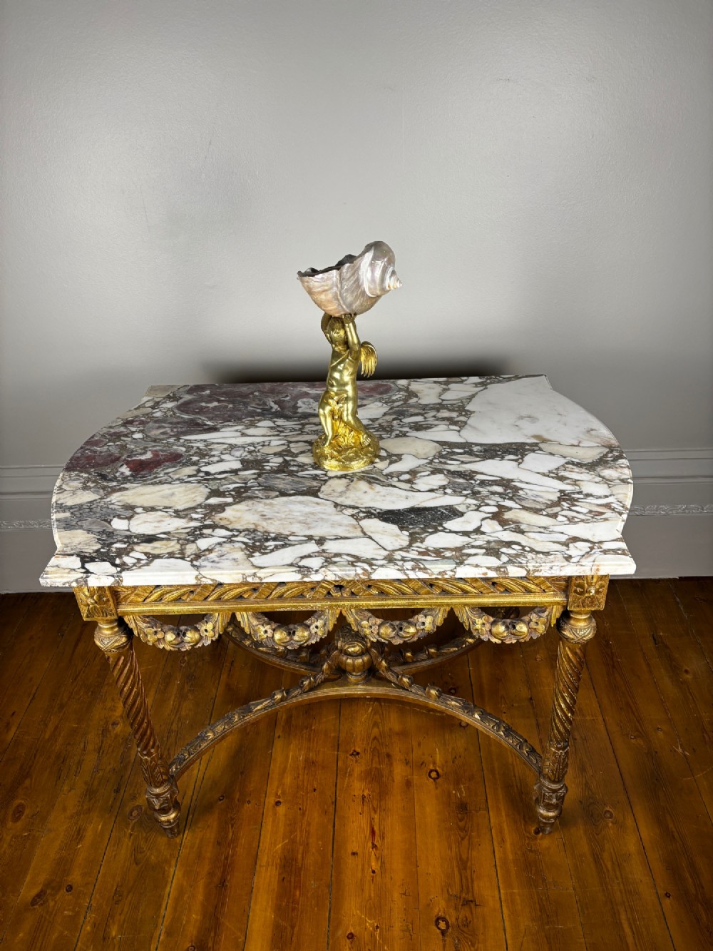 An early 20th-century French Louis XV Revival giltwood console table with a carved openwork apron, spiralled legs, curved stretcher, and fitted white marble top. View IX