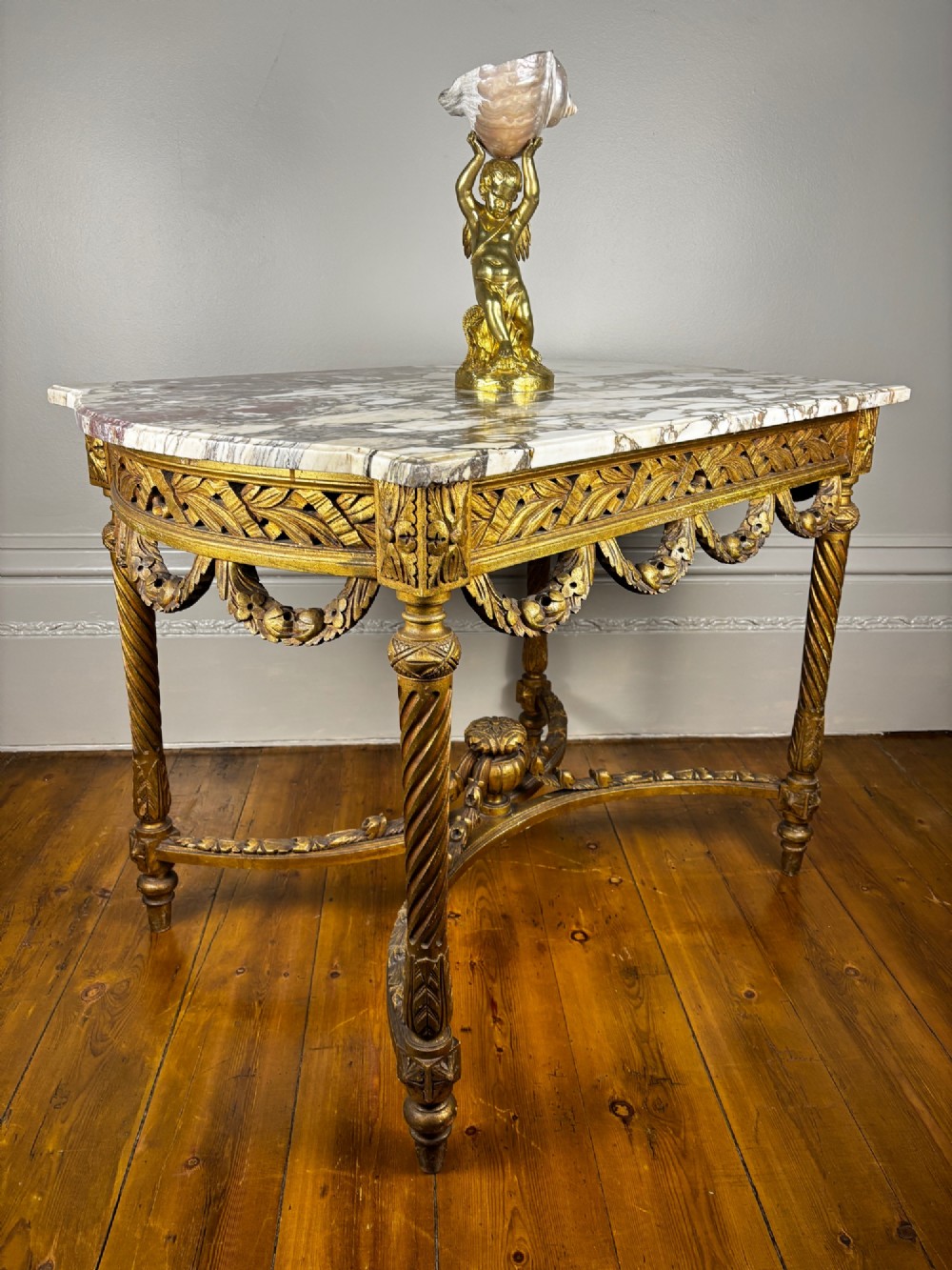 An early 20th-century French Louis XV Revival giltwood console table with a carved openwork apron, spiralled legs, curved stretcher, and fitted white marble top. View XI
