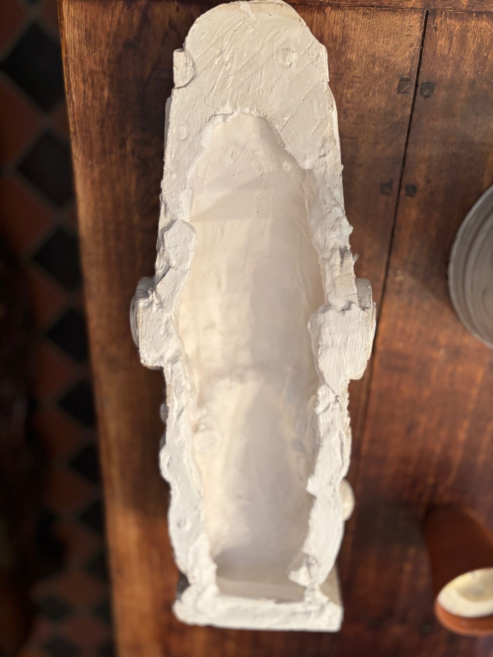 A carved off-white 19th-century wall corbel featuring a detailed winged putto head above layered acanthus leaves. View XV