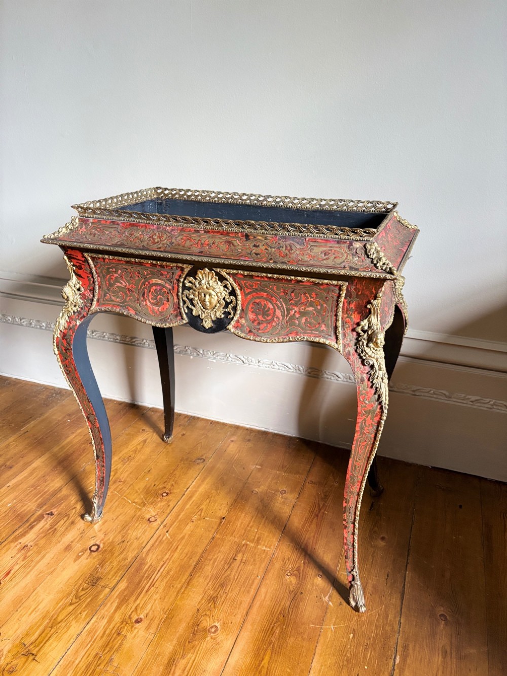 A 19th-century French Napoleon III jardiniere stand featuring red tortoiseshell and brass marquetry inlay, gilt bronze mounts, and curved cabriole legs. View II