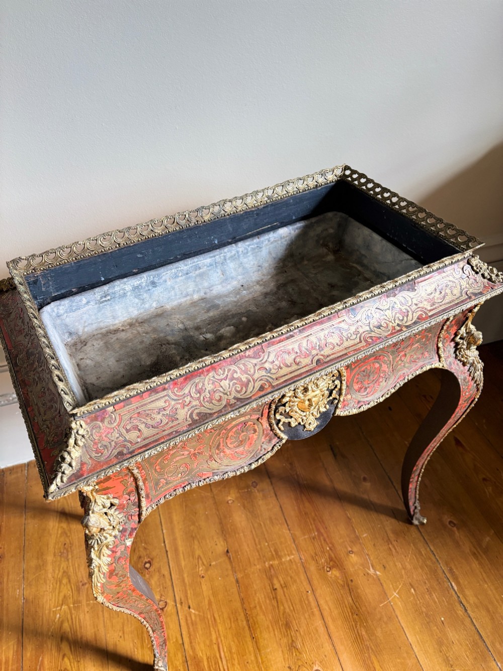 A 19th-century French Napoleon III jardiniere stand featuring red tortoiseshell and brass marquetry inlay, gilt bronze mounts, and curved cabriole legs. View III