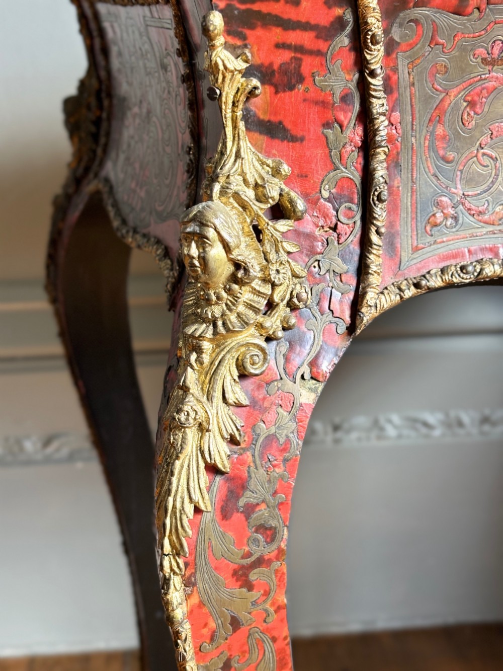 A 19th-century French Napoleon III jardiniere stand featuring red tortoiseshell and brass marquetry inlay, gilt bronze mounts, and curved cabriole legs. View VI