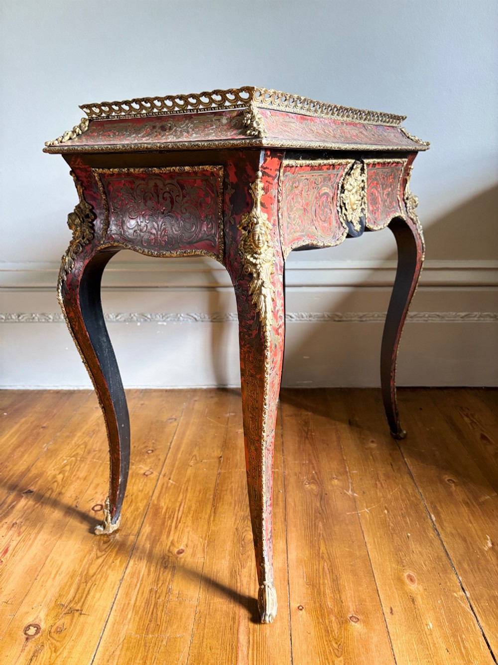 A 19th-century French Napoleon III jardiniere stand featuring red tortoiseshell and brass marquetry inlay, gilt bronze mounts, and curved cabriole legs. View VIII