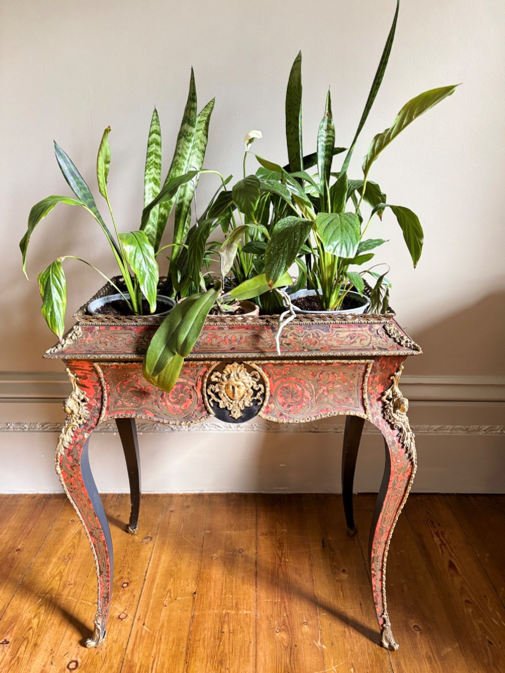 A 19th-century French Napoleon III jardiniere stand featuring red tortoiseshell and brass marquetry inlay, gilt bronze mounts, and curved cabriole legs. View IX