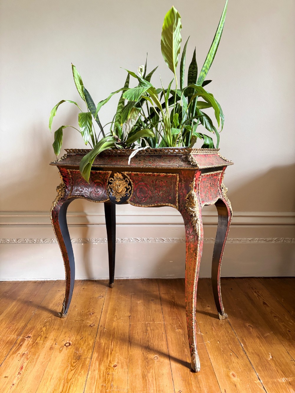A 19th-century French Napoleon III jardiniere stand featuring red tortoiseshell and brass marquetry inlay, gilt bronze mounts, and curved cabriole legs. View X