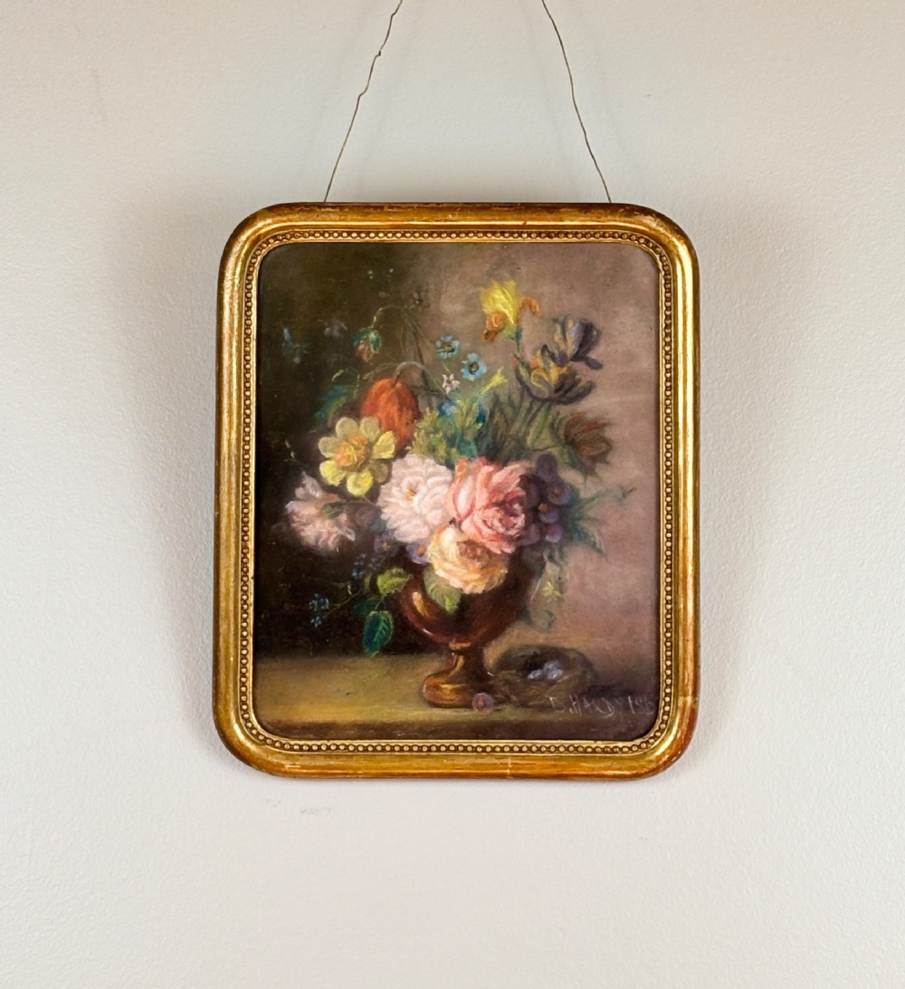 A framed 1815 Georgian pastel painting depicting a floral bouquet in an urn with a small birds nest on a ledge, enclosed in a gilded frame with rounded corners. View II