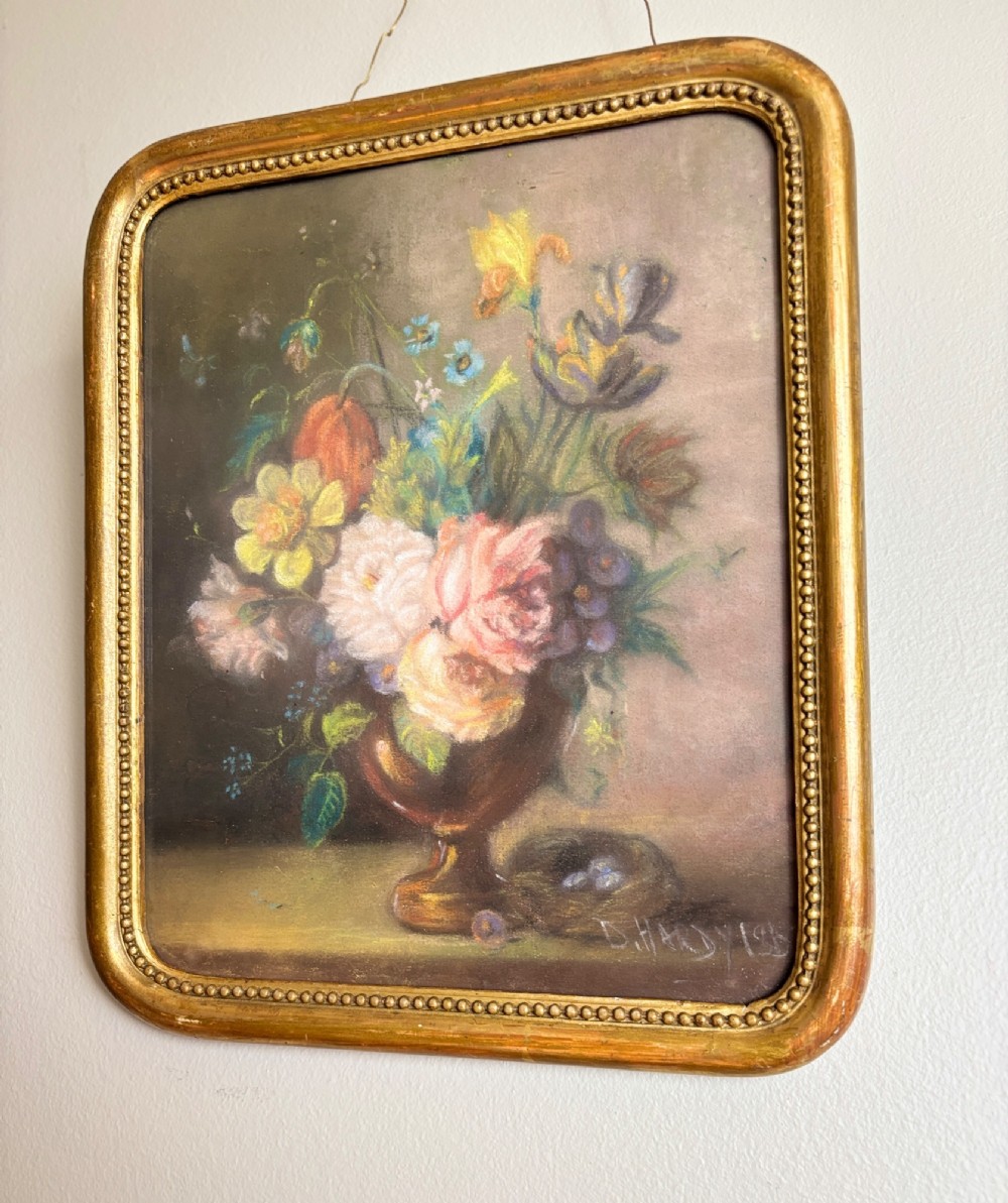 A framed 1815 Georgian pastel painting depicting a floral bouquet in an urn with a small birds nest on a ledge, enclosed in a gilded frame with rounded corners. View III