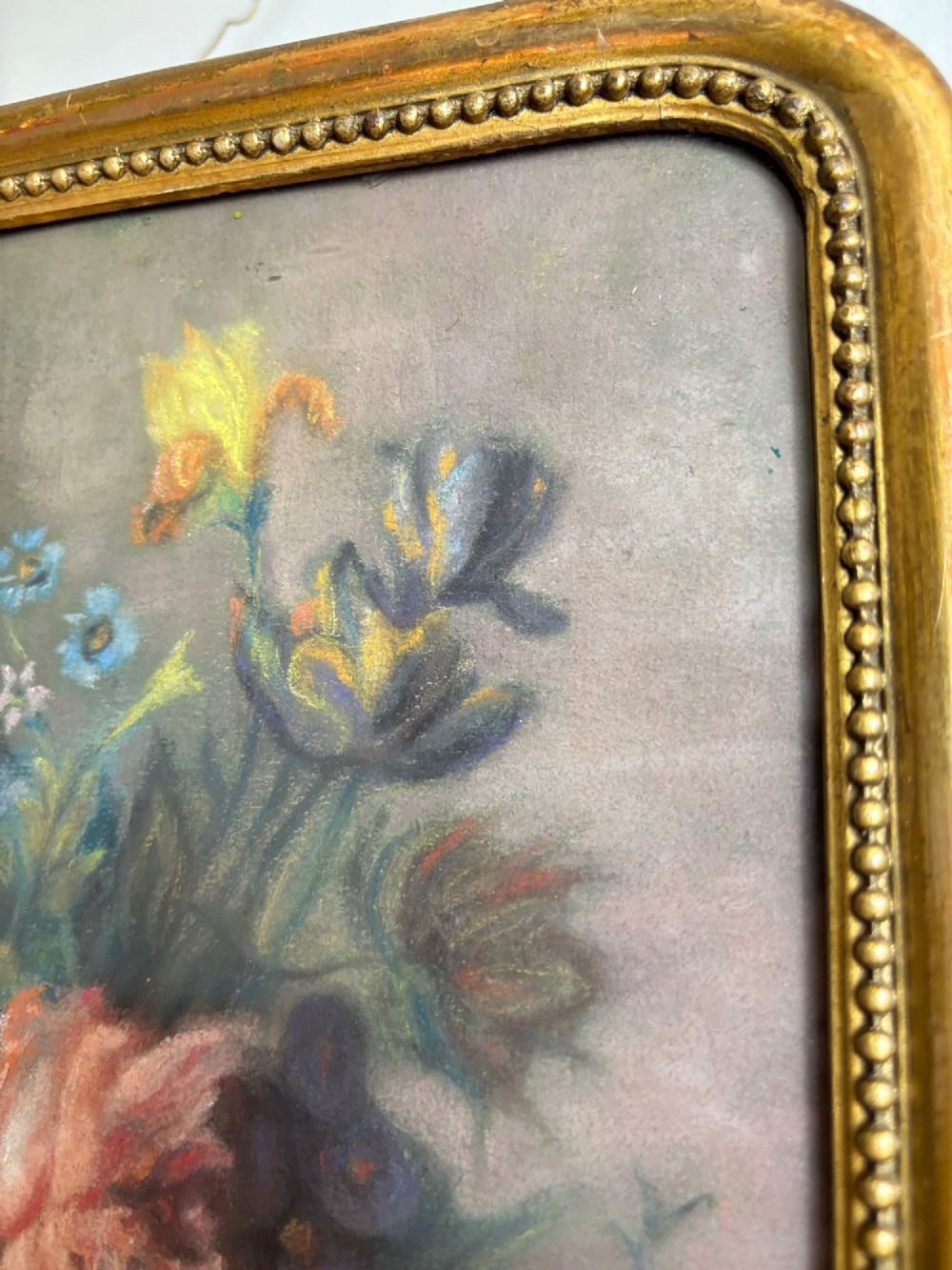 A framed 1815 Georgian pastel painting depicting a floral bouquet in an urn with a small birds nest on a ledge, enclosed in a gilded frame with rounded corners. View V