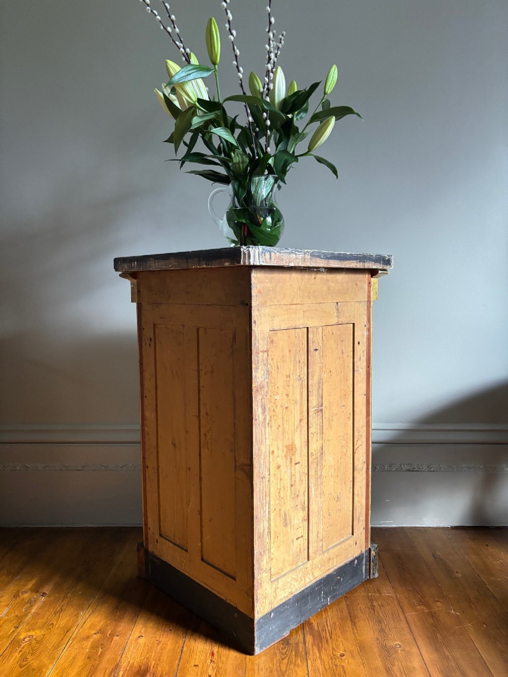 An Italian Regency period corner cupboard featuring a grey marble top, cream painted door with a gilt metal grille, fluted side columns, and decorative gilt rosettes. View XII