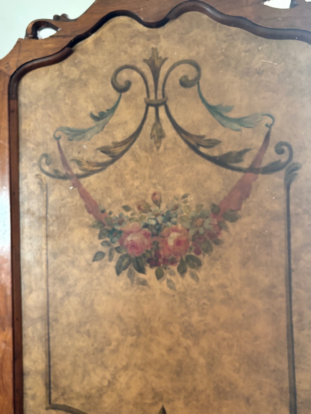 A French three-fold walnut screen featuring carved crestings and hand-painted panels depicting pastoral scenes, floral garlands, and musical trophies. View II