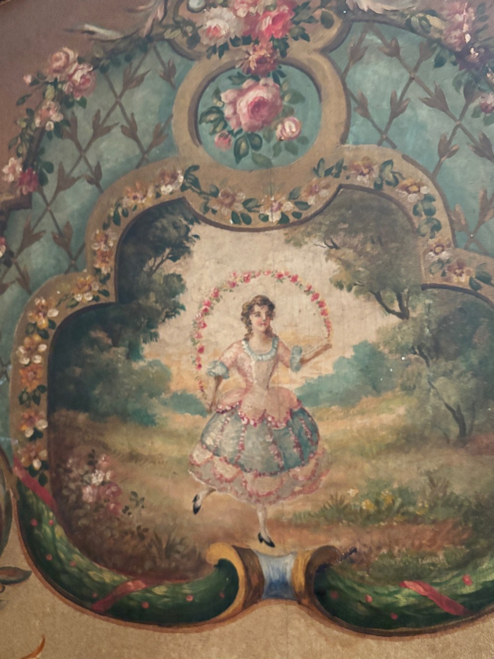A French three-fold walnut screen featuring carved crestings and hand-painted panels depicting pastoral scenes, floral garlands, and musical trophies. View V