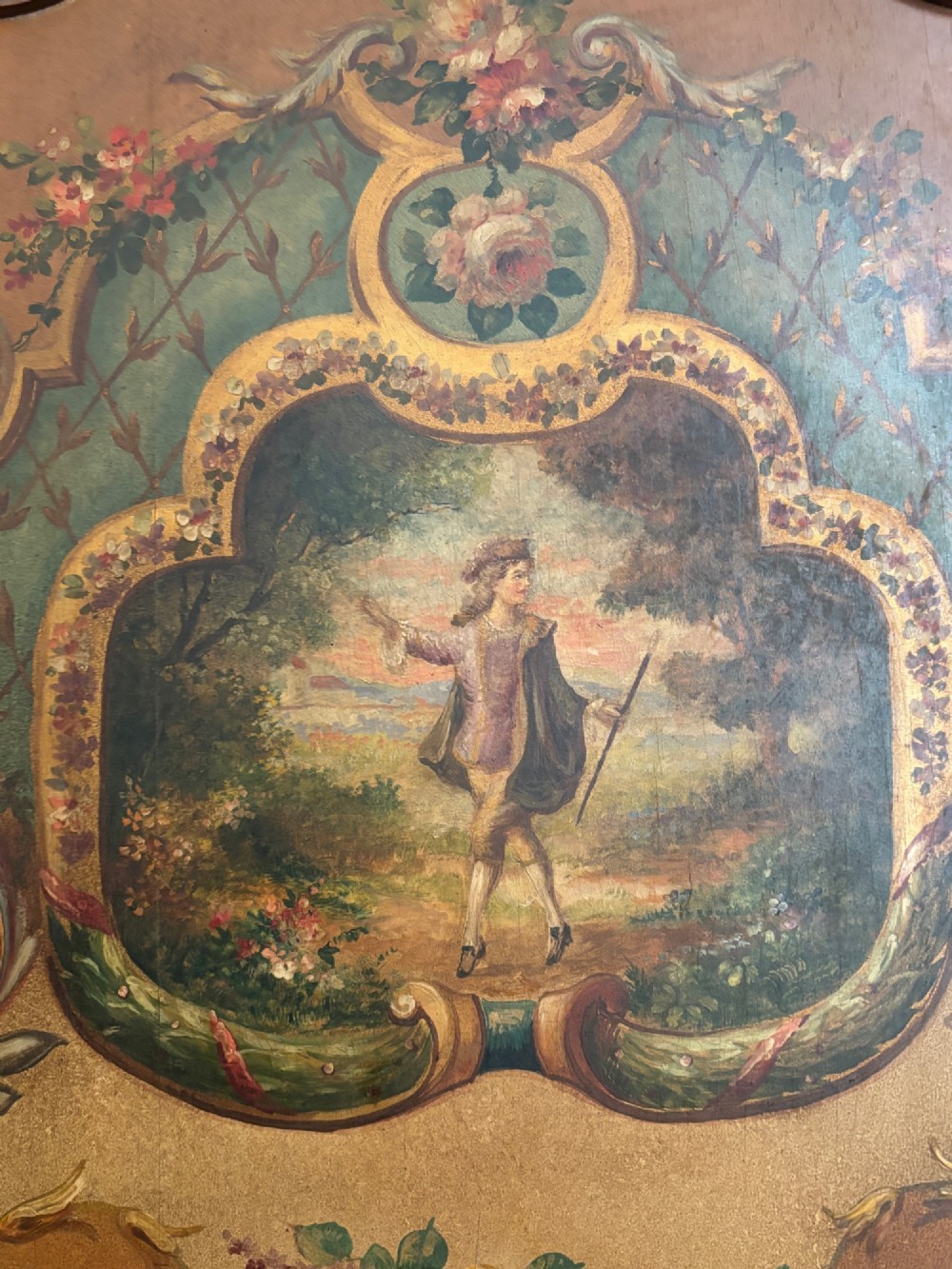 A French three-fold walnut screen featuring carved crestings and hand-painted panels depicting pastoral scenes, floral garlands, and musical trophies. View VI