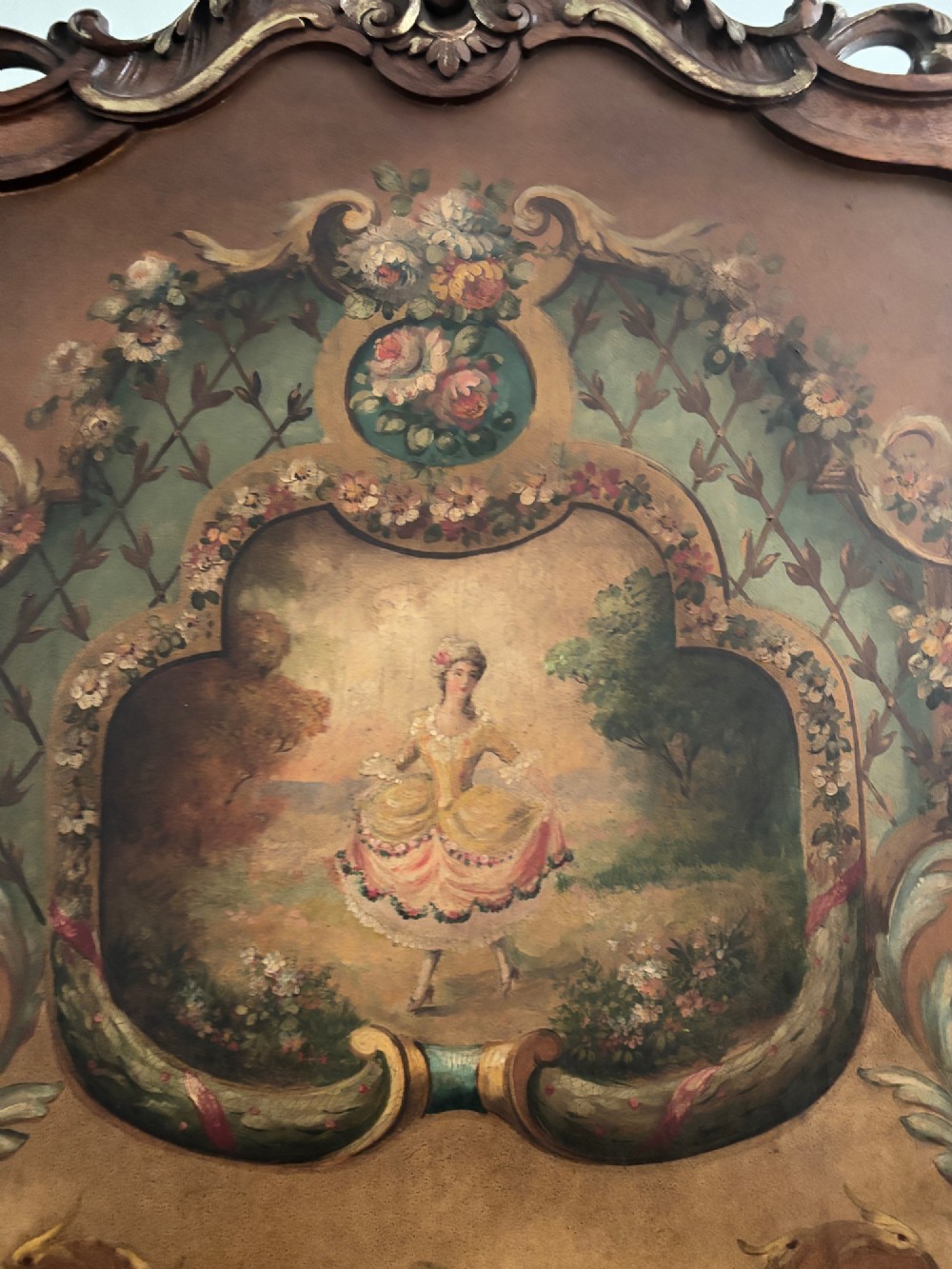 A French three-fold walnut screen featuring carved crestings and hand-painted panels depicting pastoral scenes, floral garlands, and musical trophies. View VII