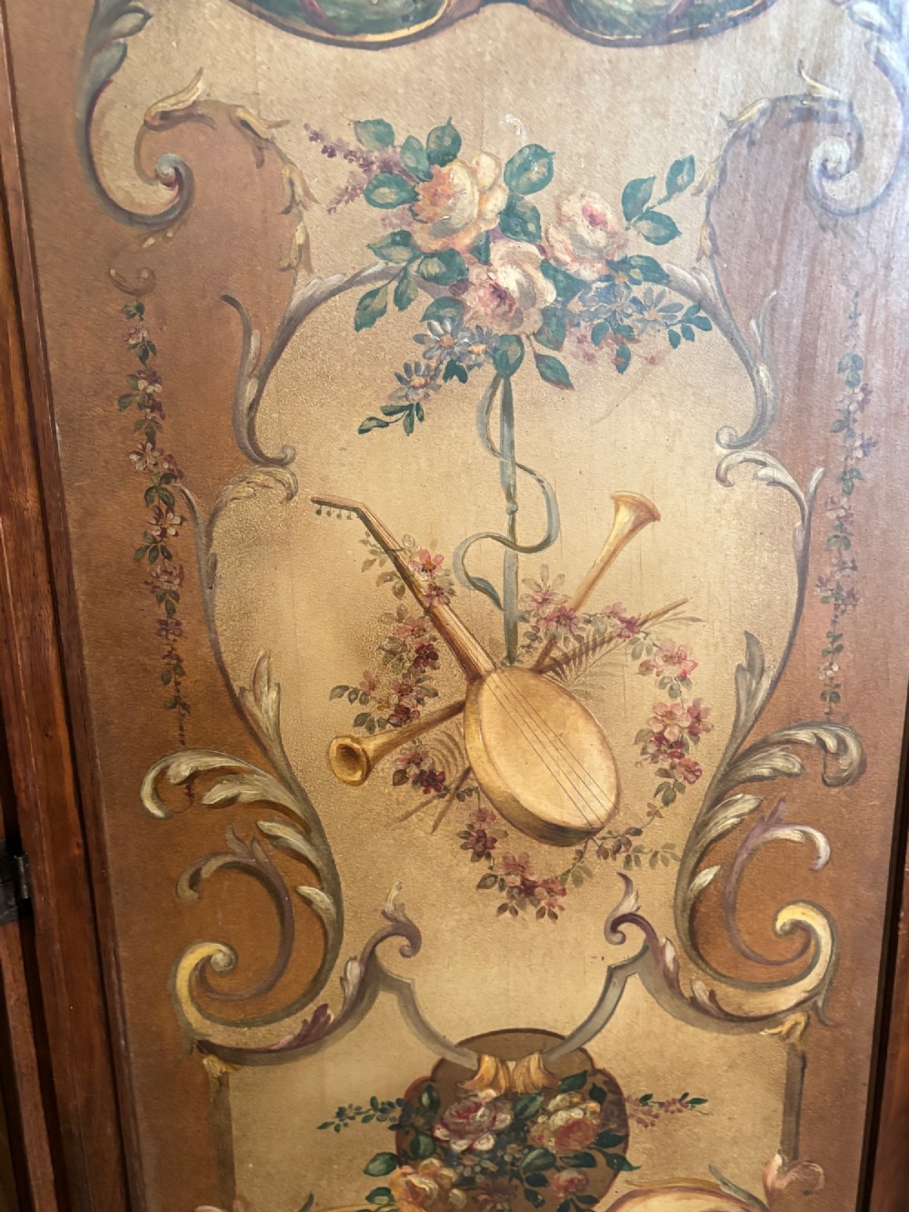 A French three-fold walnut screen featuring carved crestings and hand-painted panels depicting pastoral scenes, floral garlands, and musical trophies. View IX