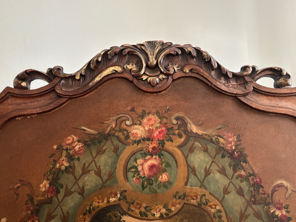A French three-fold walnut screen featuring carved crestings and hand-painted panels depicting pastoral scenes, floral garlands, and musical trophies. View XI