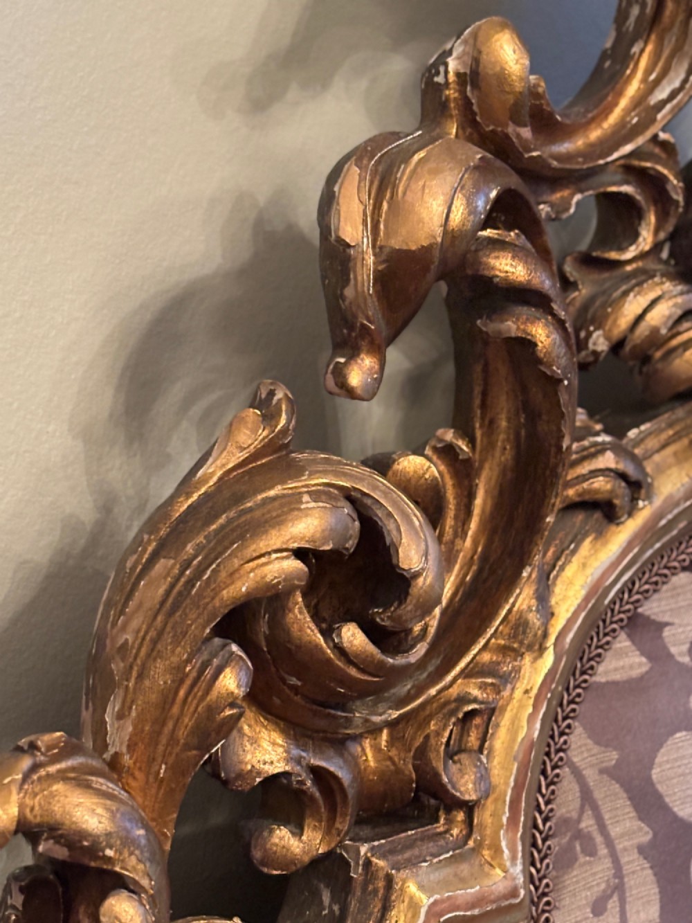 A 19th-century Italian Rococo giltwood bed frame with an ornate carved headboard and footboard upholstered in patterned damask fabric. View VI