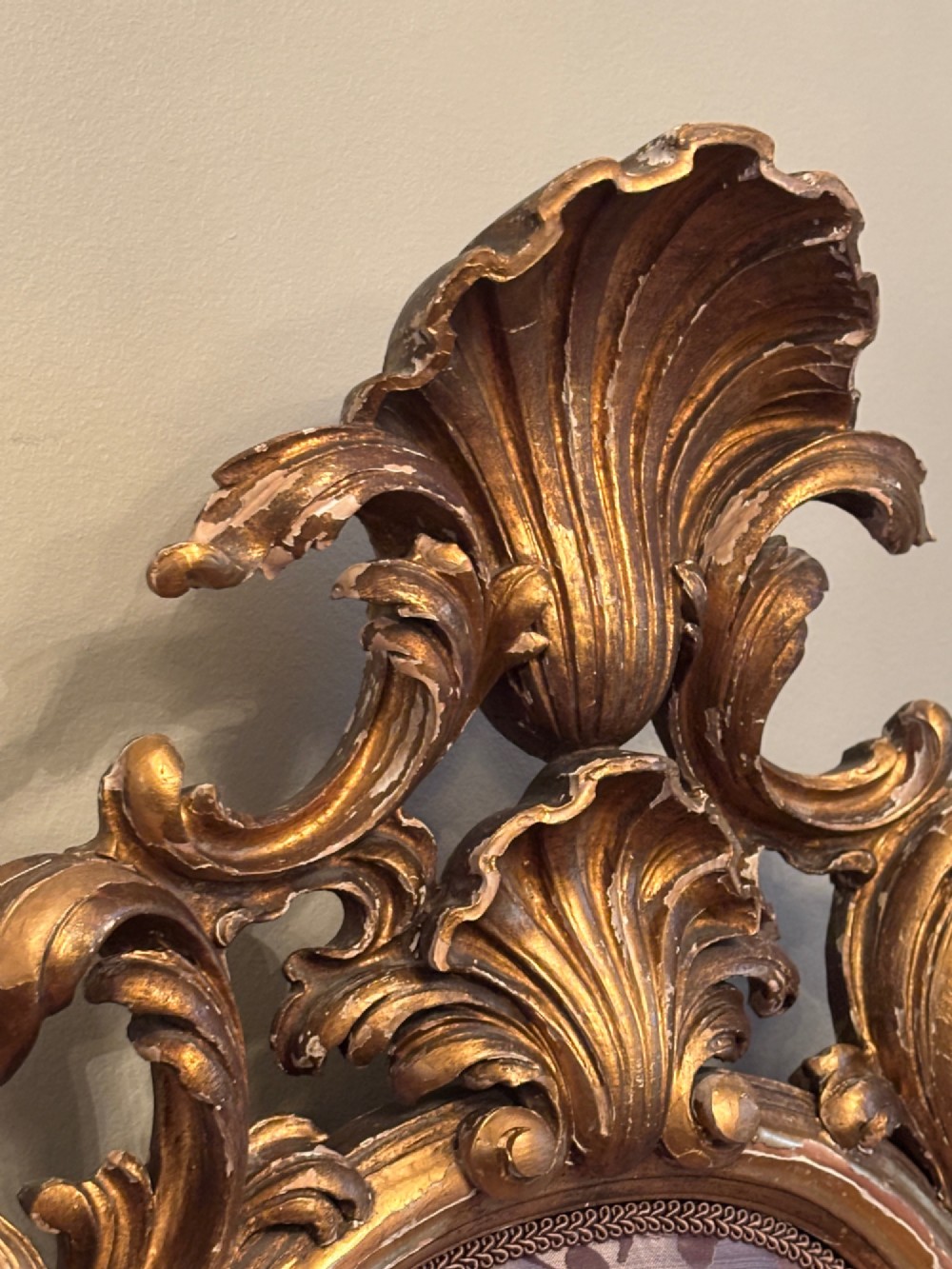 A 19th-century Italian Rococo giltwood bed frame with an ornate carved headboard and footboard upholstered in patterned damask fabric. View IX