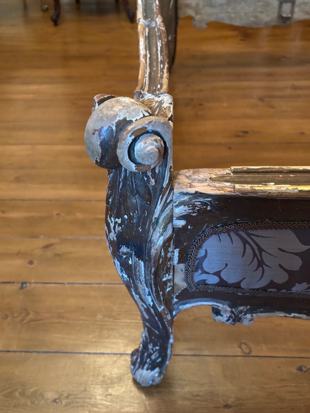 A 19th-century Italian Rococo giltwood bed frame with an ornate carved headboard and footboard upholstered in patterned damask fabric. View XII