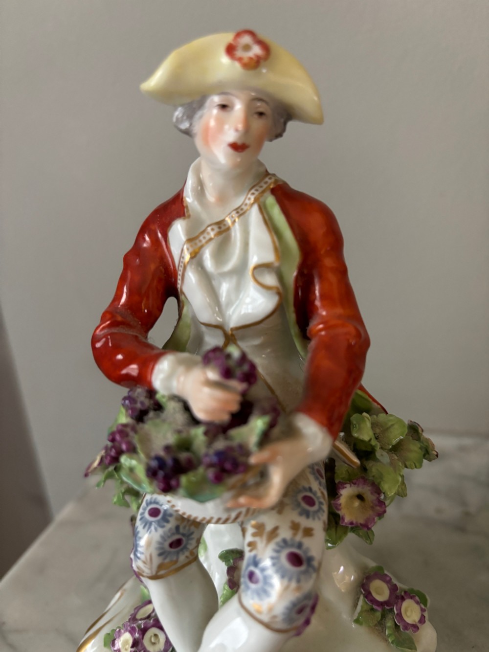 A pair of 19th-century Edme Samson hard-paste porcelain figurines depicting an 18th-century courtly man and woman in colourful enamelled attire seated on gilded rococo scroll bases. View II