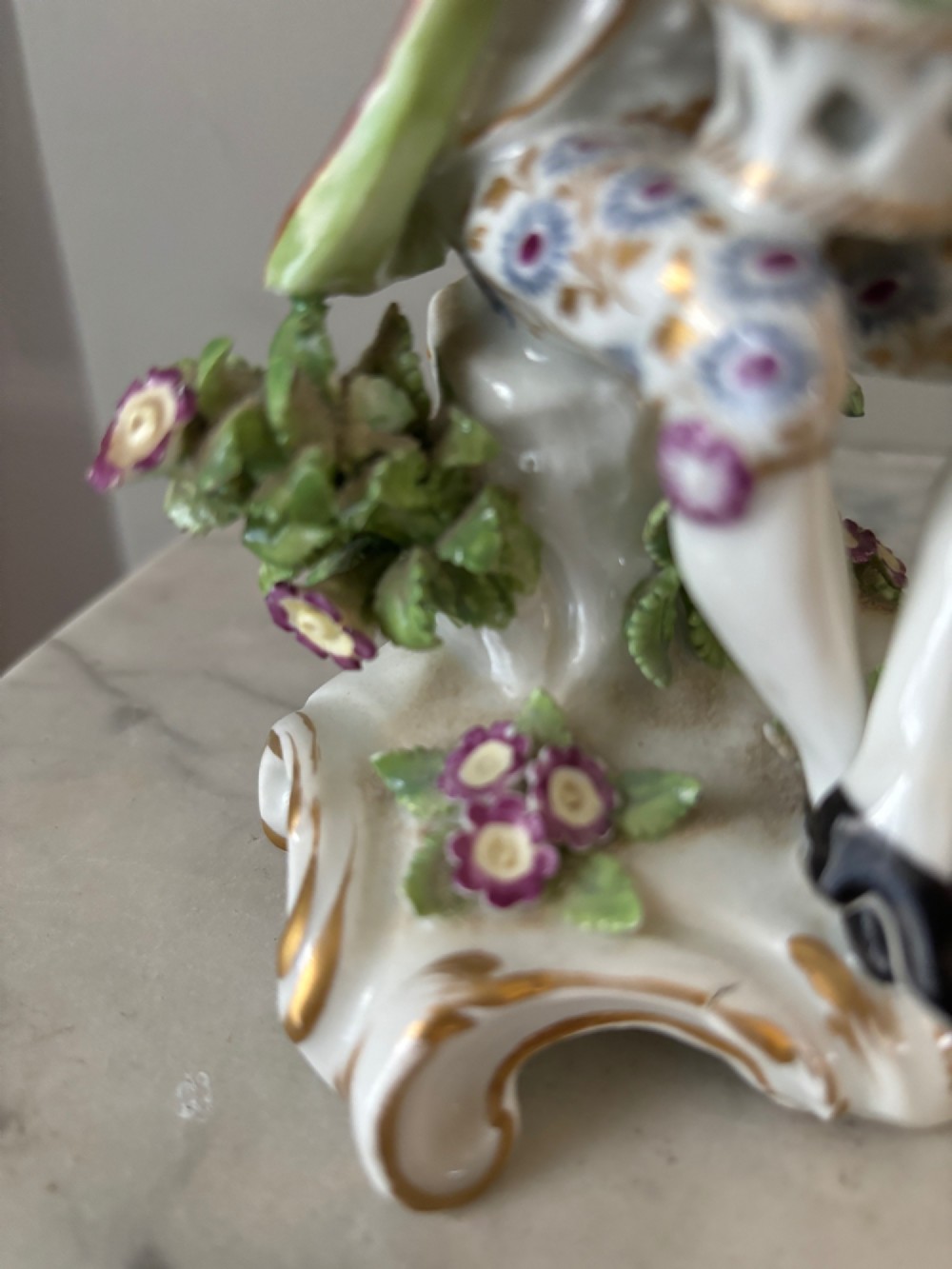 A pair of 19th-century Edme Samson hard-paste porcelain figurines depicting an 18th-century courtly man and woman in colourful enamelled attire seated on gilded rococo scroll bases. View VI