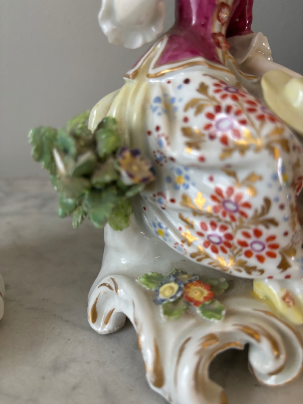 A pair of 19th-century Edme Samson hard-paste porcelain figurines depicting an 18th-century courtly man and woman in colourful enamelled attire seated on gilded rococo scroll bases. View VII