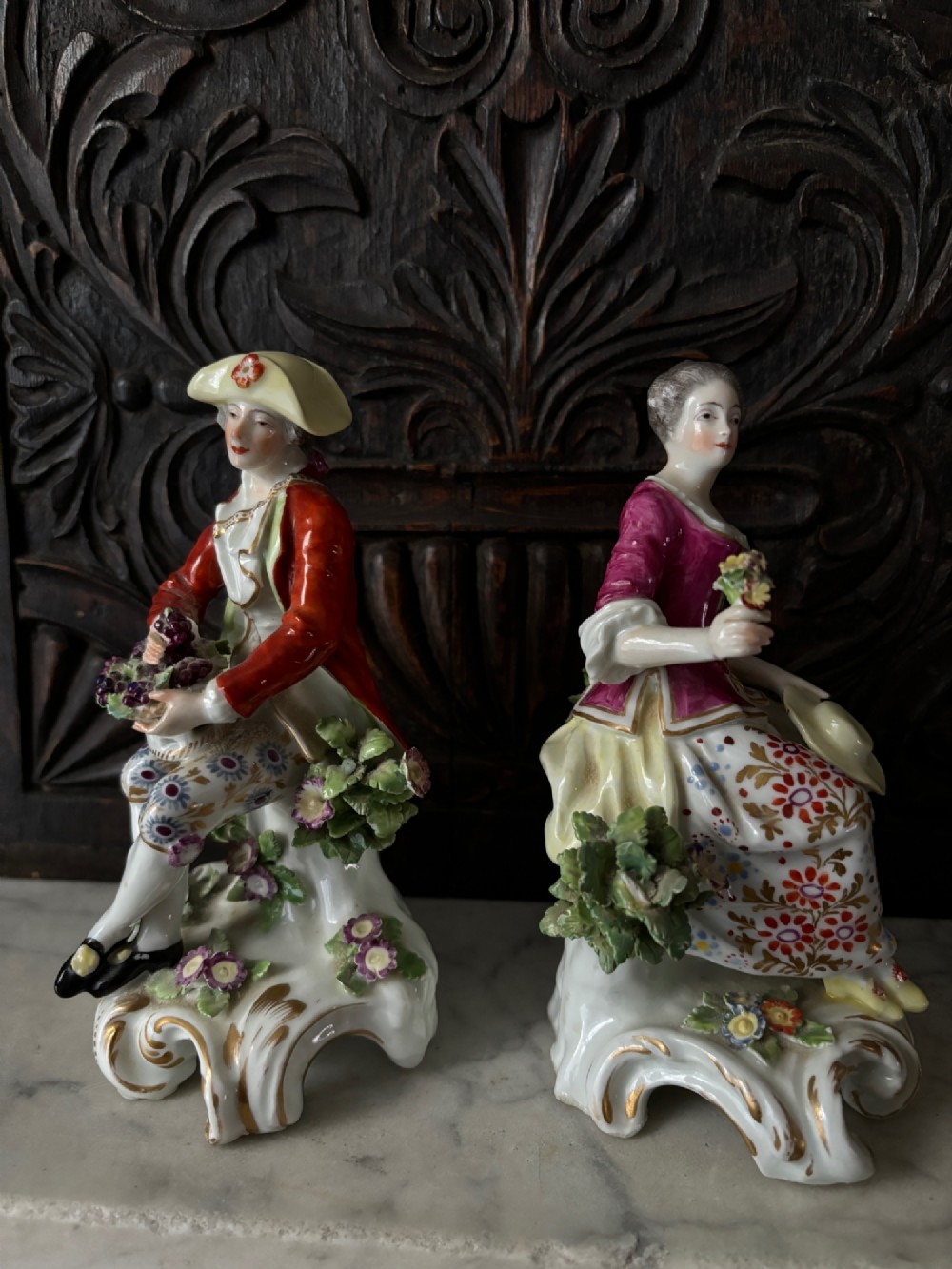 A pair of 19th-century Edme Samson hard-paste porcelain figurines depicting an 18th-century courtly man and woman in colourful enamelled attire seated on gilded rococo scroll bases. View VIII