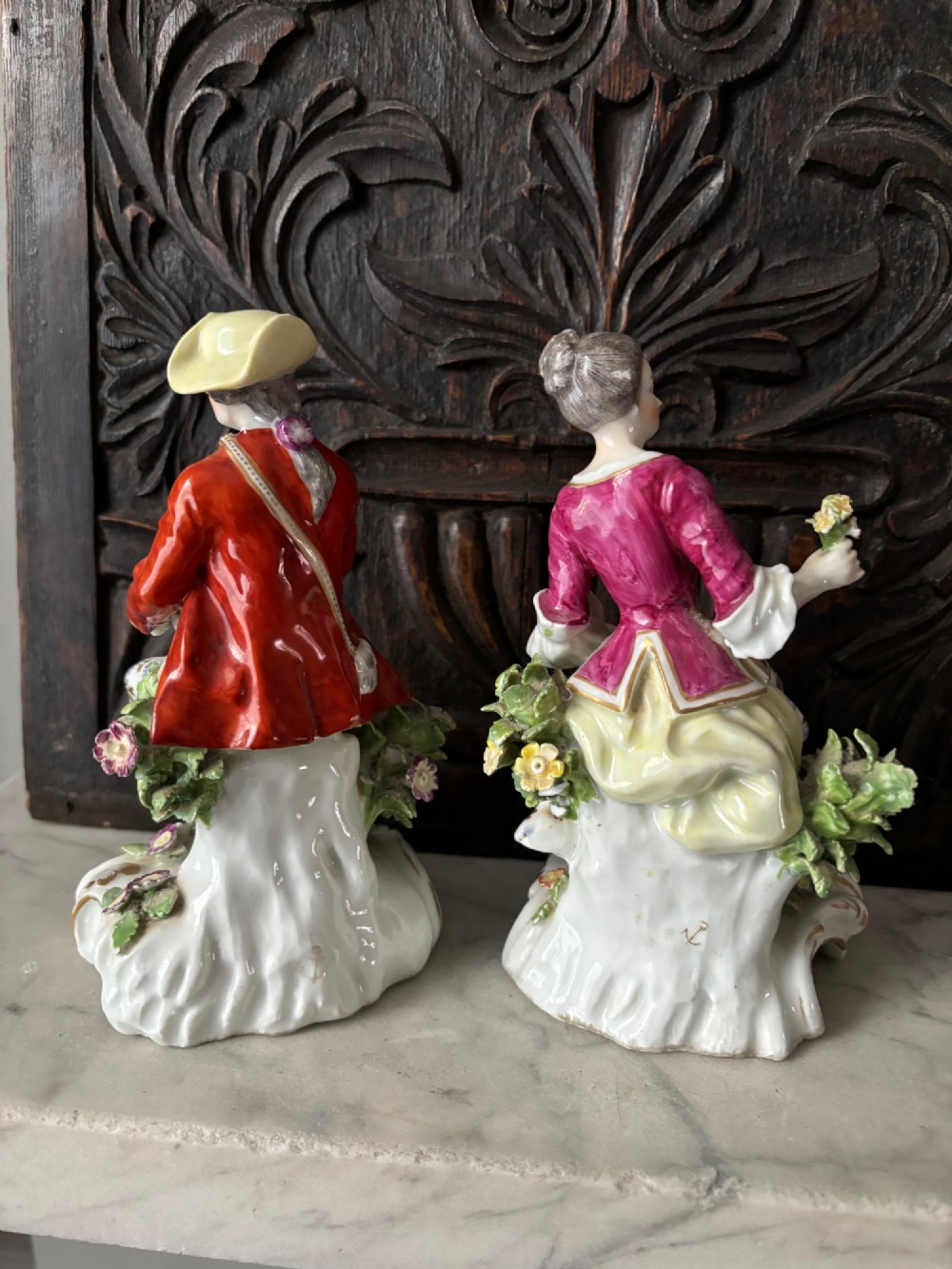 A pair of 19th-century Edme Samson hard-paste porcelain figurines depicting an 18th-century courtly man and woman in colourful enamelled attire seated on gilded rococo scroll bases. View X