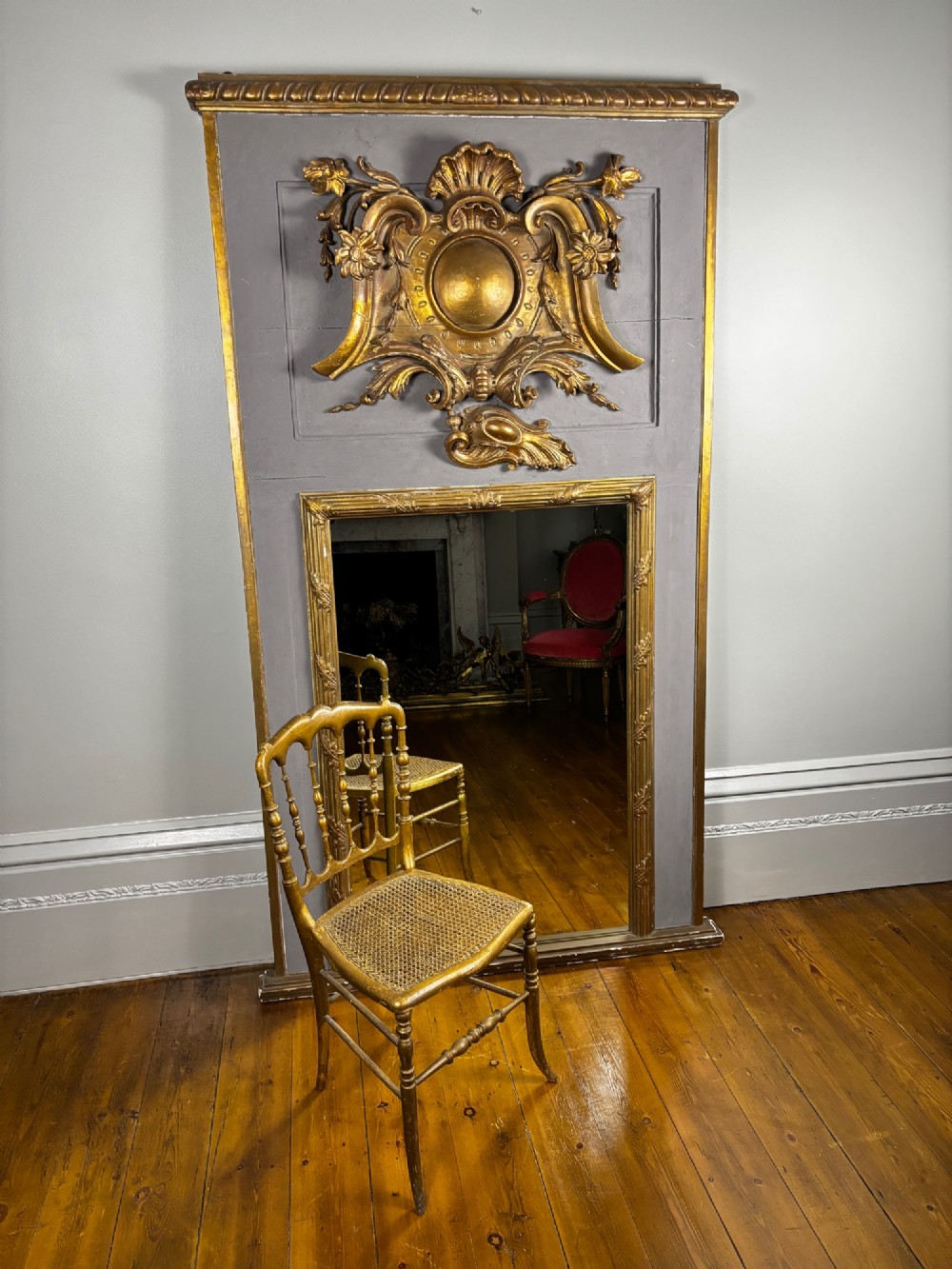 A 19th-century French giltwood salon chair featuring turned spindles, a woven cane seat, and slender curved legs with a distressed gold finish. View V