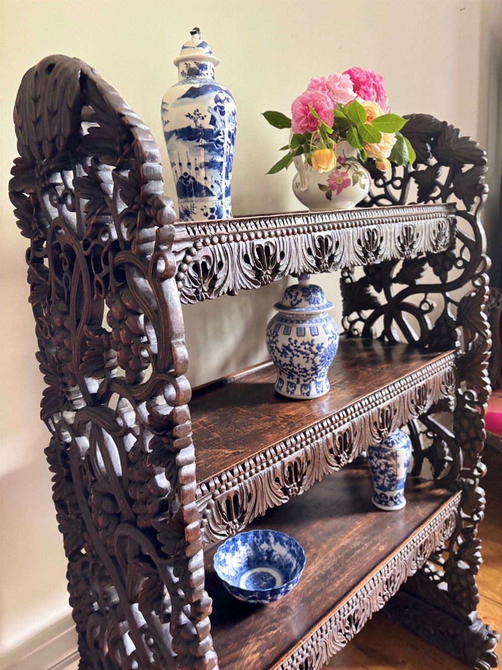 A 19th-century three-tiered Anglo-Indian padauk shelving unit featuring deeply carved floral friezes, openwork side panels, and sculpted feet. View IX