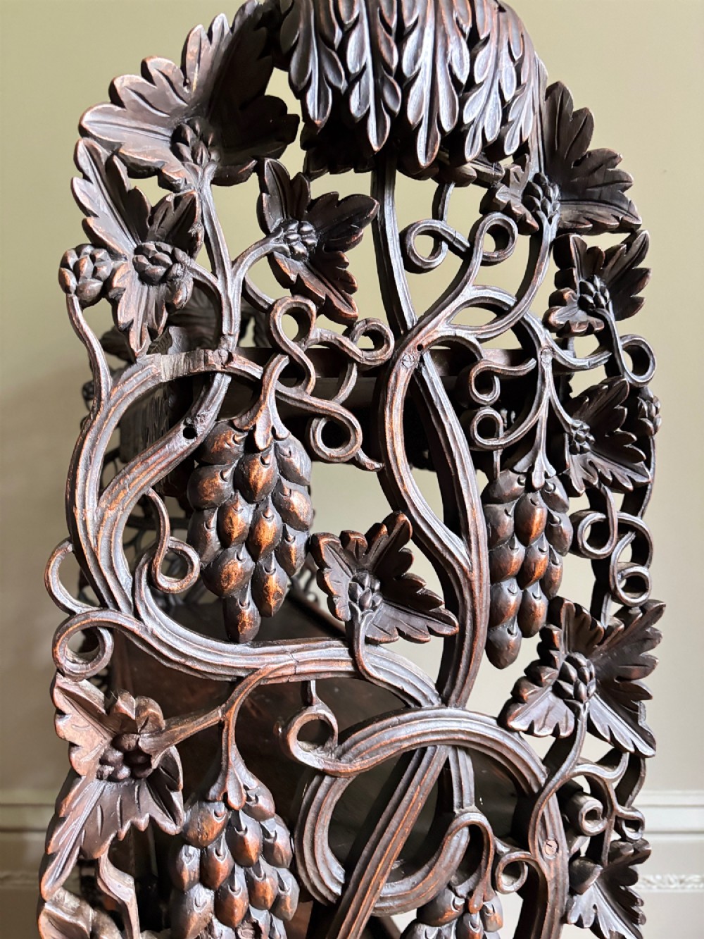 A 19th-century three-tiered Anglo-Indian padauk shelving unit featuring deeply carved floral friezes, openwork side panels, and sculpted feet. View XIV