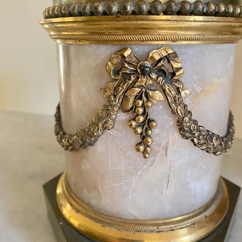 A pair of patinated bronze putti figures standing on marble pedestals, each holding gilt bronze scrollwork candelabra arms. View XI