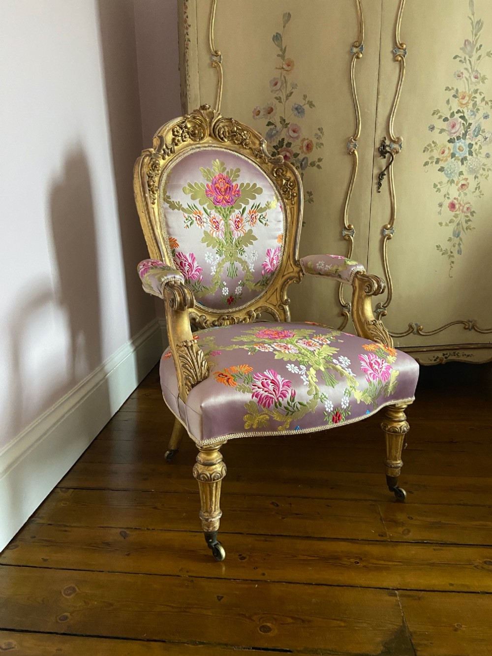A 19th-century Rococo Revival open armchair with a carved giltwood frame and pink floral silk upholstery. View II