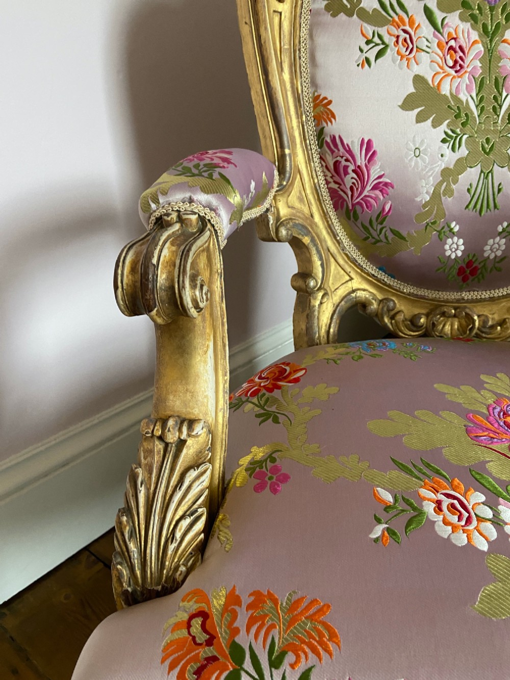A 19th-century Rococo Revival open armchair with a carved giltwood frame and pink floral silk upholstery. View IV
