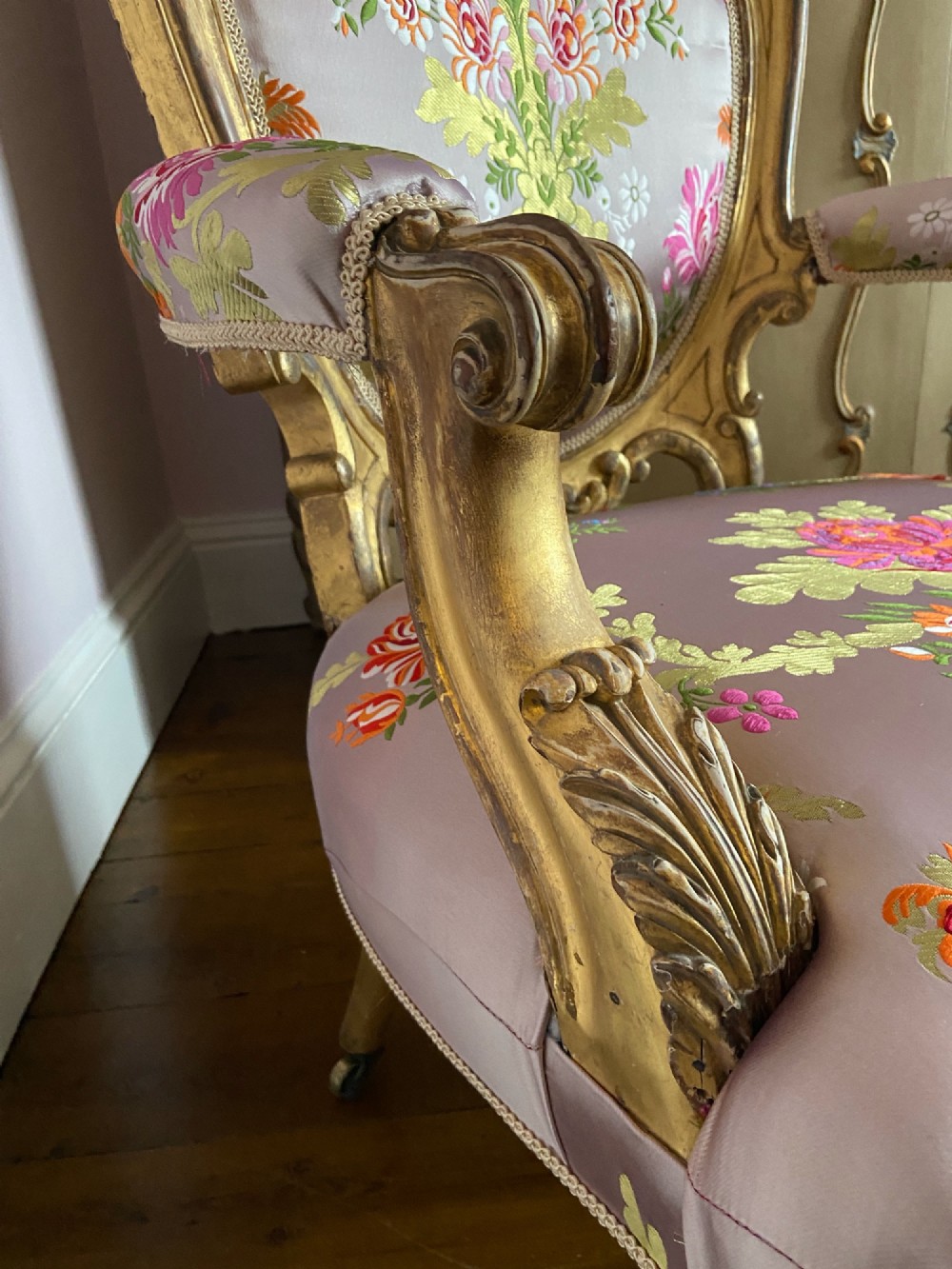 A 19th-century Rococo Revival open armchair with a carved giltwood frame and pink floral silk upholstery. View V
